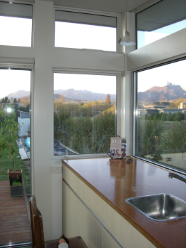 Earth House — kitchen corner window framing a mountain view