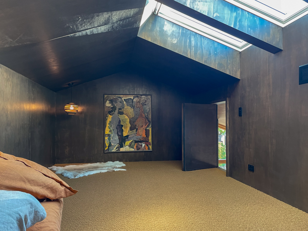 Garden House — mezzanine loft beneath the dark-stained roof, with skylight